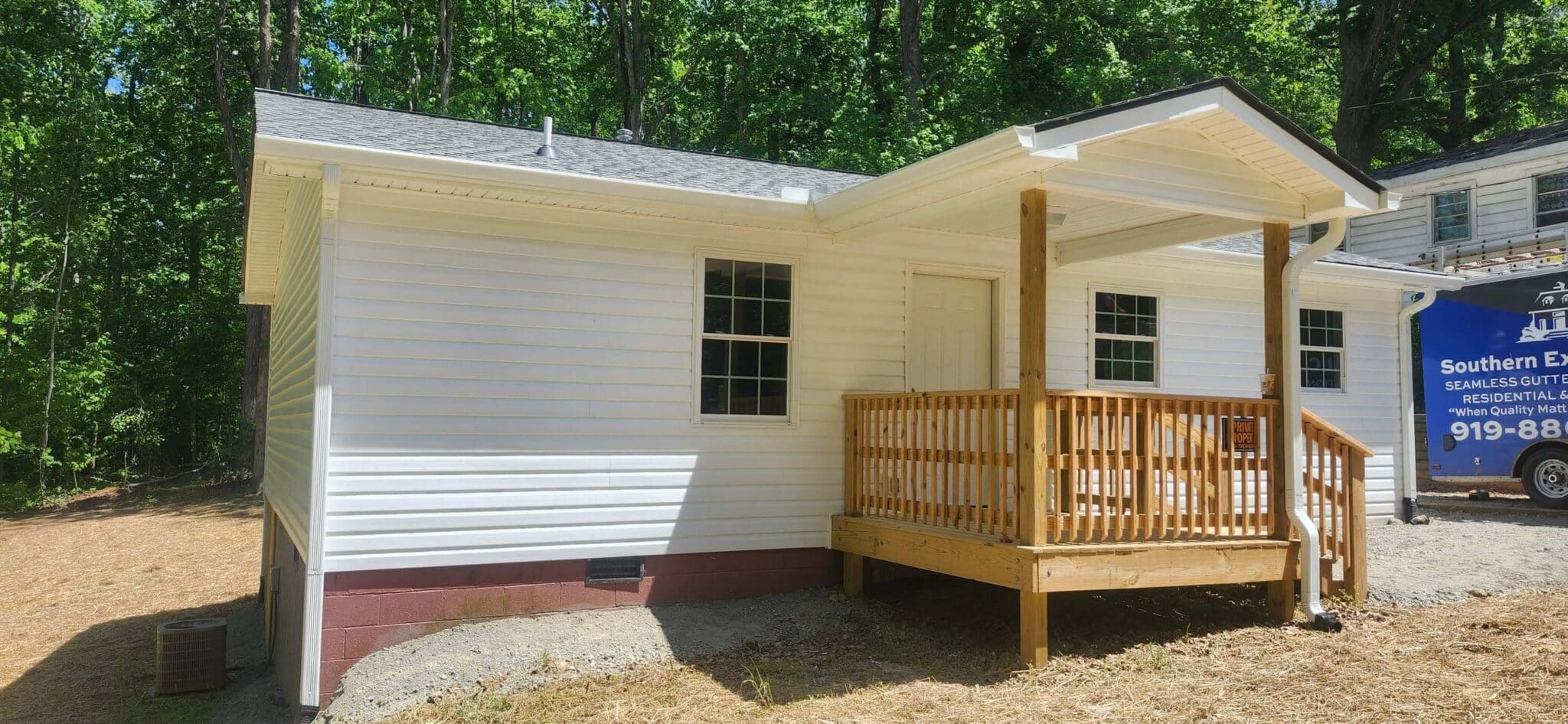 white house with new installed downspout and gutters